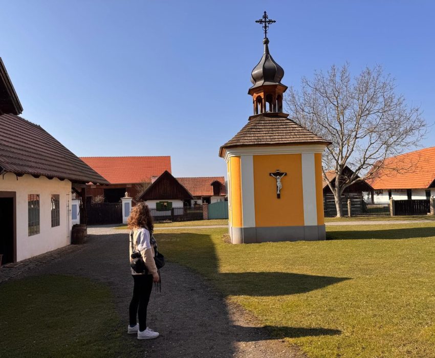 Small yellow chapel with cross and bare tree