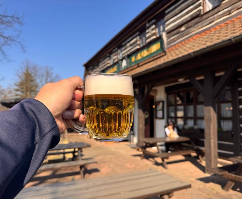 Hand holding Czech beer at a pub terrace