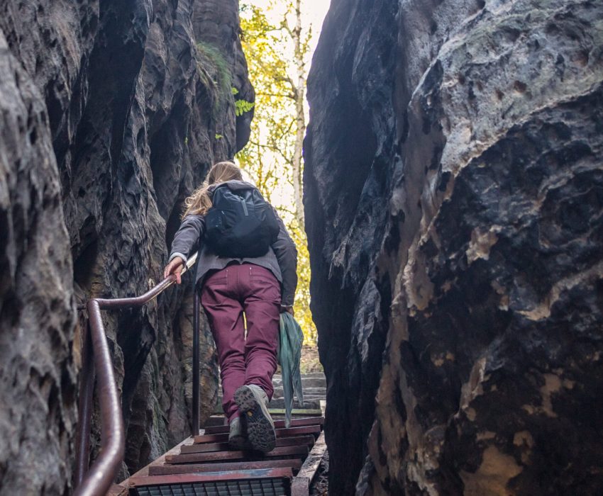 Person hiking through narrow sandstone gorge